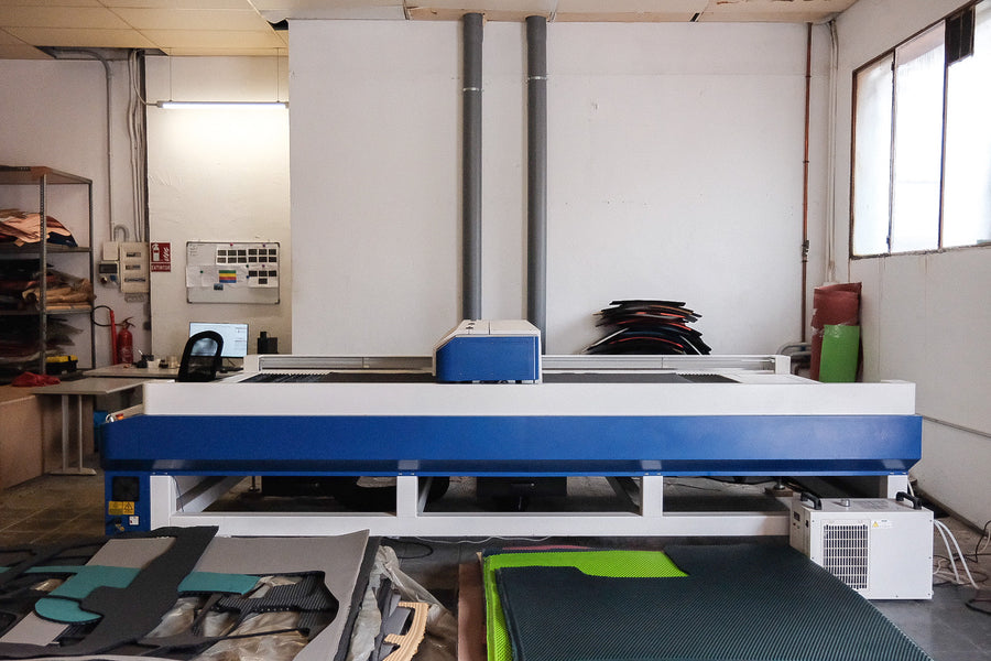 Máquina de corte láser fabricando alfombrillas a medida